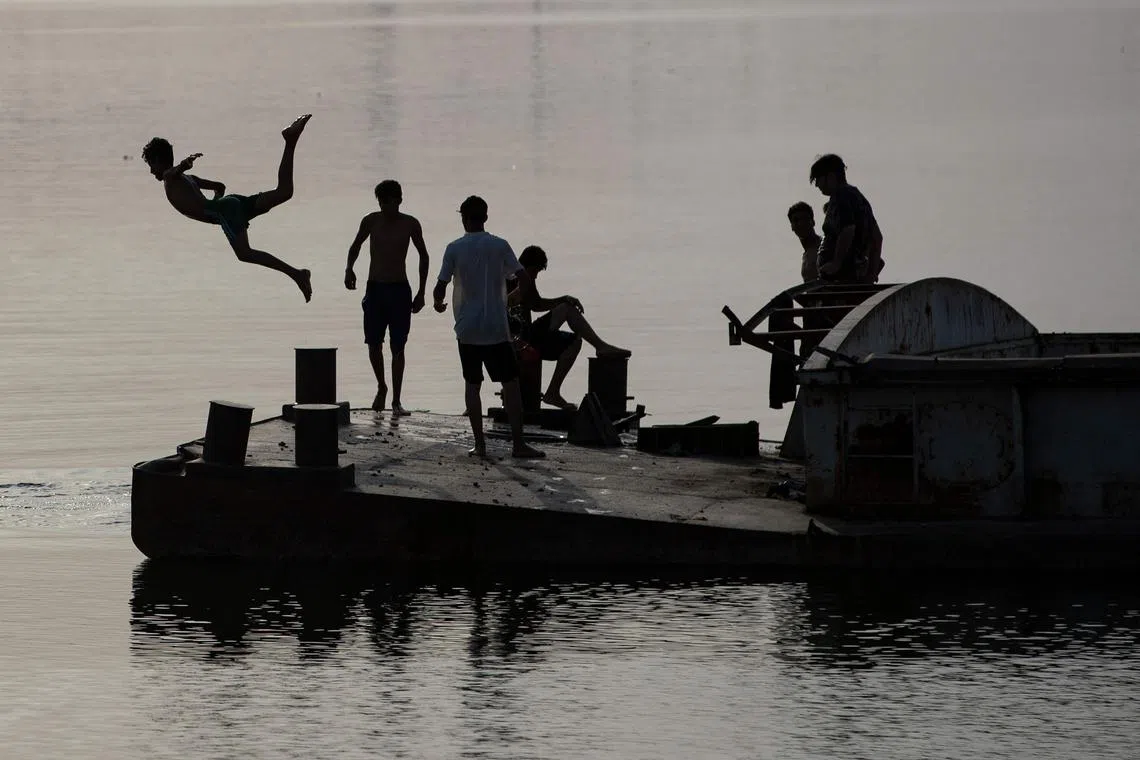 Youths swimming in the Shatt al-Arab waterway, formed at the confluence of the Euphrates and Tigris rivers, in Iraq's southern city of Basra, on May 23.