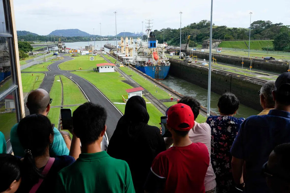 Tourists watching a cargo ship transit through the Panama Canal in Panama City on Dec 23, 2024.