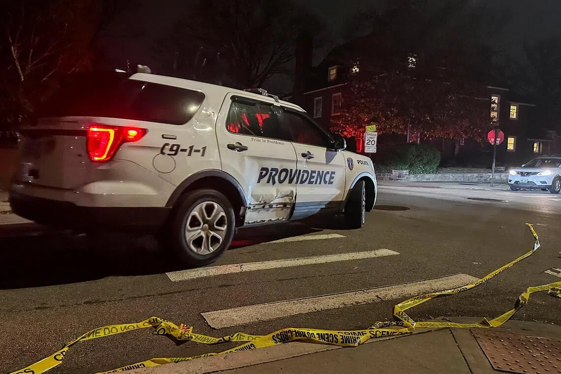 A police vehicle drives past police tape lying in the street after a shooting incident at Brown University in Providence, Rhode Island, on Dec 13, 2025.