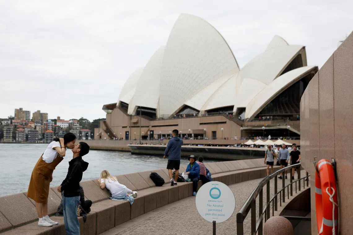 Chinese tourists pose for a photographer (not pictured) near the Sydney Opera House, Australia April 18, 2018. REUTERS/Edgar Su/File Photo