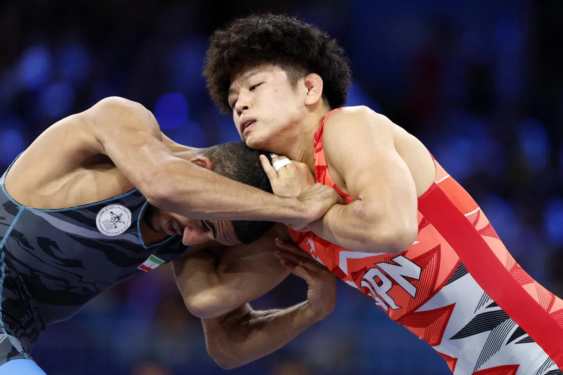 Kotaro Kiyooka of Japan in the men's wrestling freestyle 65kg final against Rahman Amouzad Khalili of Iran at the Paris Olympics in the Champs-de-Mars Arena on Aug 11, 2024.