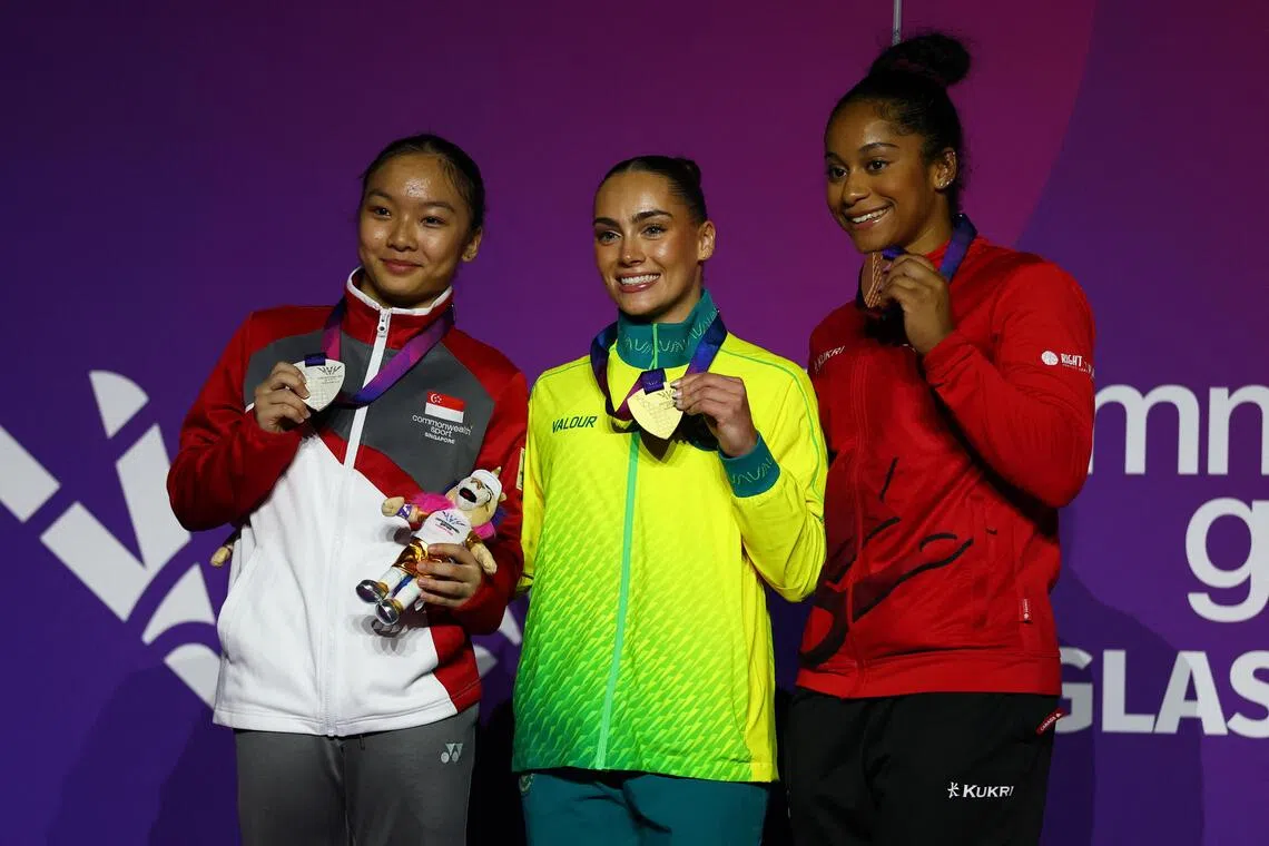 Gold medallist Australia’s Breanna Scott celebrates on the podium after winning the Women’s Balance Beam with silver medallist Singapore’s Amanda Yap and bronze medalist Canada’s Lia-Monica Fontaine.