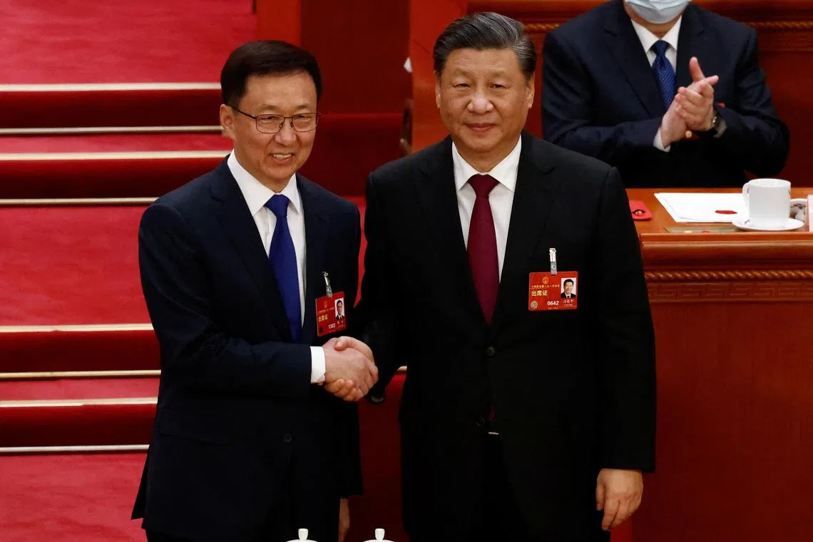 Chinese President Xi Jinping (rght) shakes hands with Senior Vice Premier Han Zheng at the Great Hall of the People, on March 10, 2023.