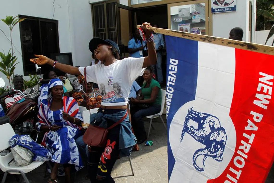 A supporter of Ghana's presidential candidate Nana Akufo-Addo of the opposition New Patriotic Party (NPP) holds a party flag as she reacts at party's headquaters in Accra, Ghana December 8, 2016. REUTERS/Luc Gnago/File Photo