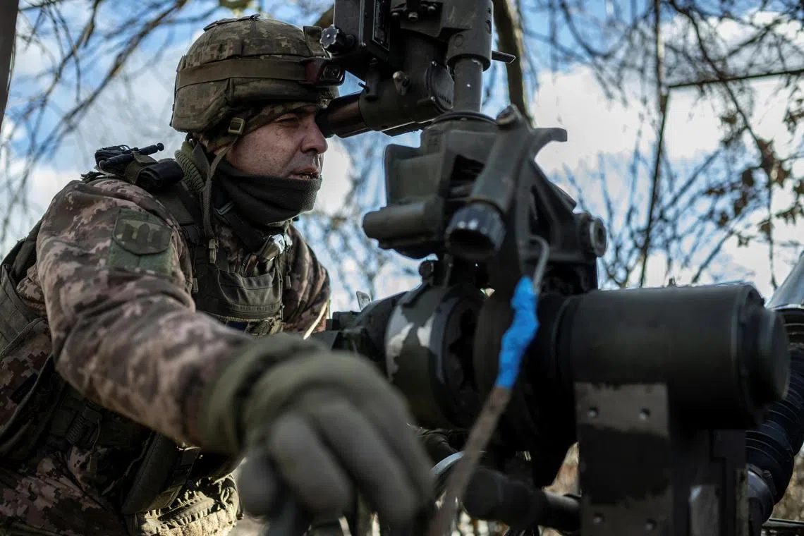 A Ukrainian serviceman points an M777 howitzer towards Russian troops, near the front-line town of Maryinka, in Ukraine's Donetsk region.