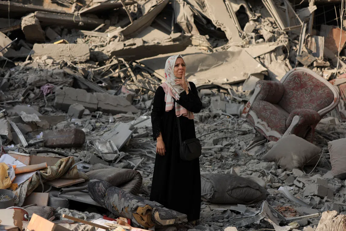 A Palestinian woman inspects the damage at the site of Israeli strikes that destroyed Al-Jundi al-Majhoul residential tower on Sunday, in Gaza City, September 15, 2025. REUTERS/Dawoud Abu Alkas