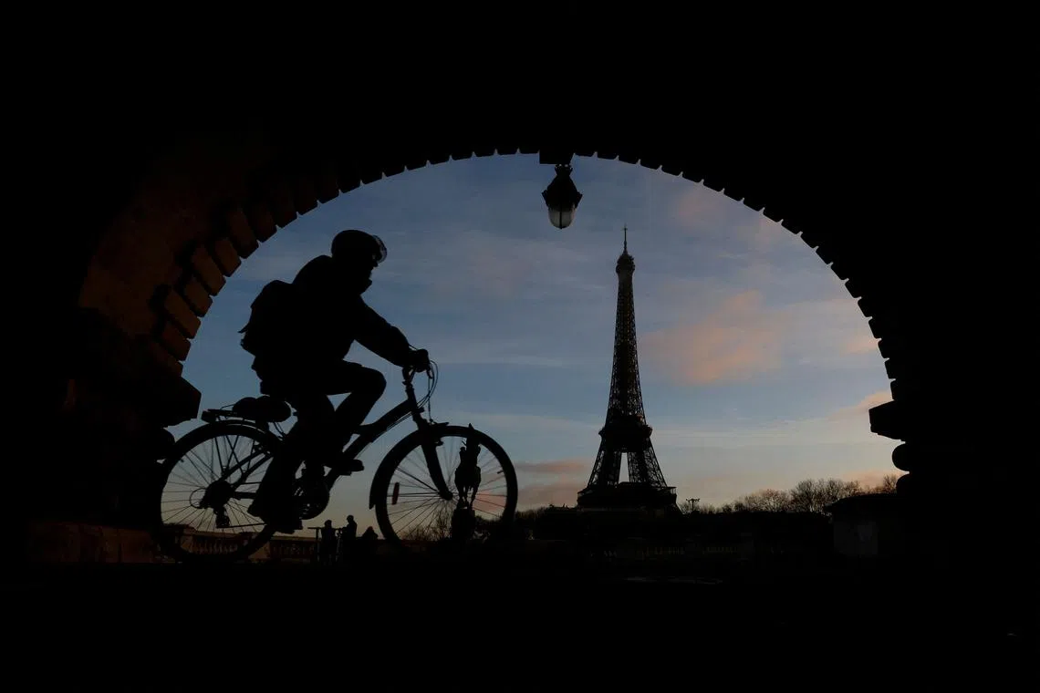 A man rides a bicycle along a bike path on the Pont de Bir-Hakeim bridge near the Eiffel Tower in Paris during a nationwide day of strike and protests against the French government's pension reform plan in France, Jan 19, 2023. 