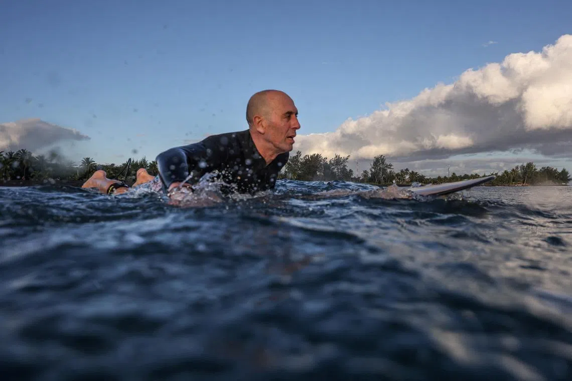 FILE PHOTO: Fernando Aguerre, president of the International Surfing Association, waits for a wave as he surfs at a local beach in Papara, Tahiti, July 24, 2024. REUTERS/Carlos Barria/File Photo
