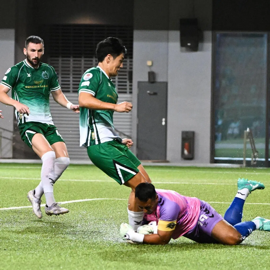 Tanjong Pagar United Goalkeeper Zaiful Nizam (right) saving the ball and was injured in the process as Geylang International forward Shuhei Hoshino (second from right) attacks a 50-50 ball.