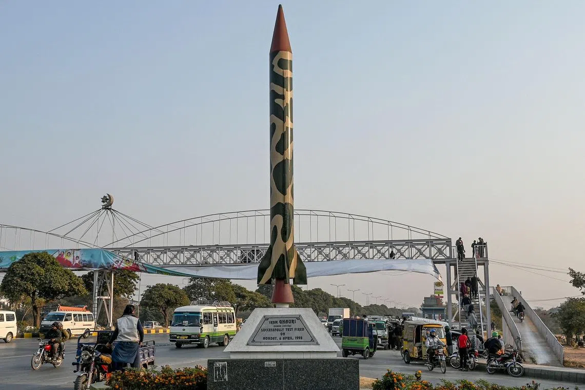 Commuters riding past a replica of Pakistan's Ghauri ballistic missile, in Islamabad on Dec 19.