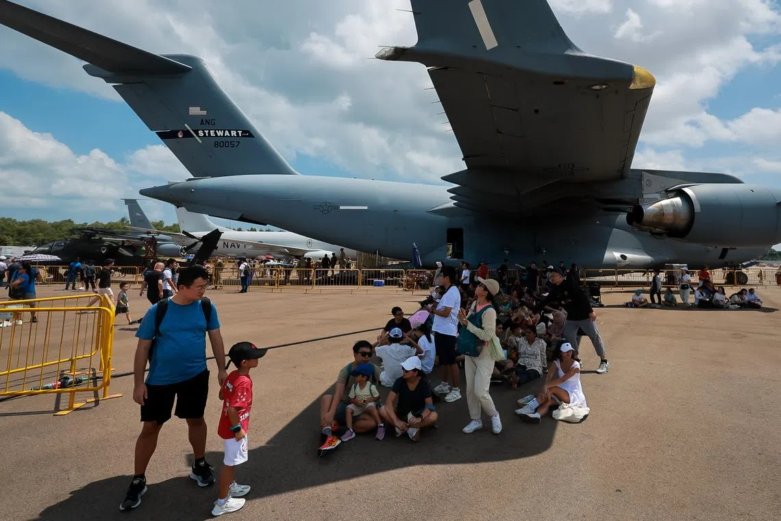 Visitors taking shelter under the US Air Force C-17 aircraft’s wing at the Singapore Airshow, Feb 25, 2024.