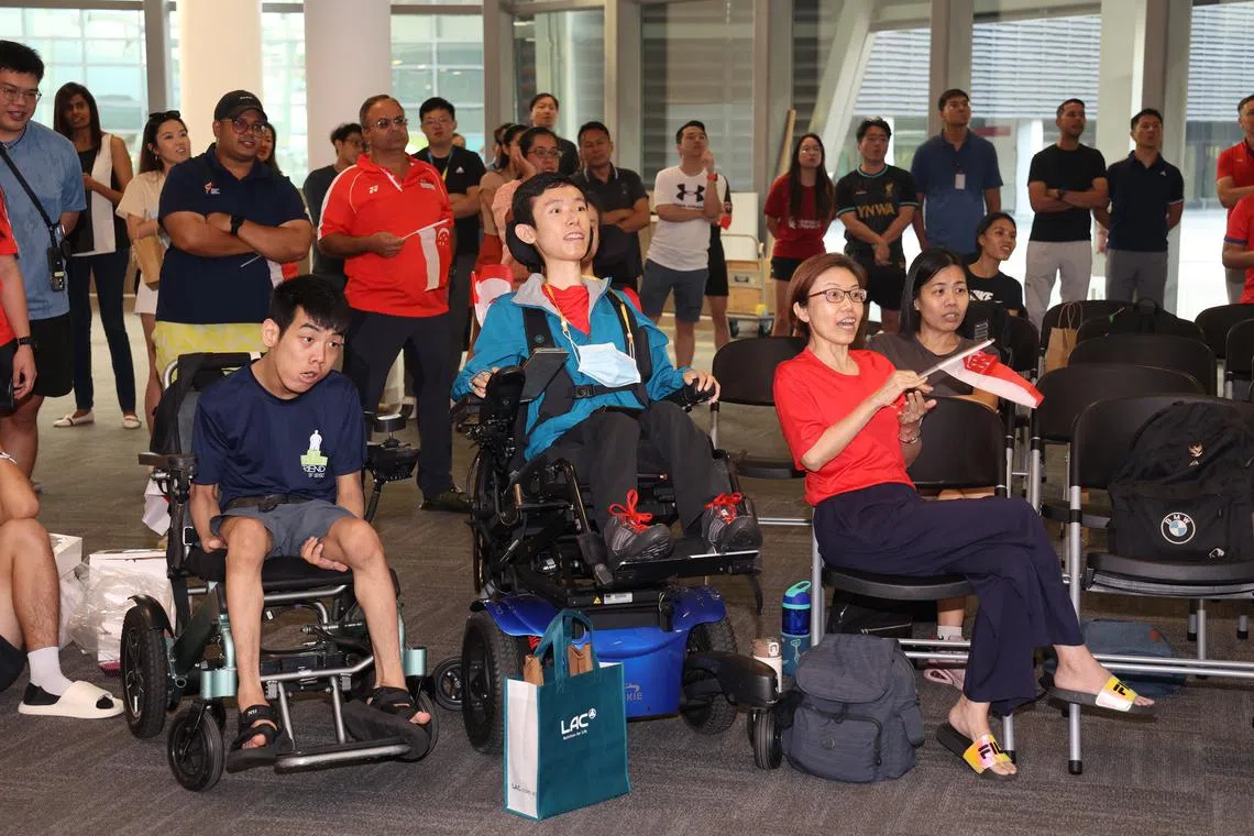 National youth boccia player Aloysius Gan (left) and national boccia player Gareth Ho (centre) at a watch party at the Singapore Sports Hub for Jeralyn Tan's women’s BC1 final.