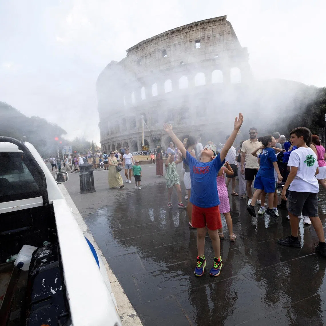 People cool off under a water mist near the Colosseum as Italy’s Civil Protection deploys measures to help residents and tourists cope with a heatwave, in Rome, Italy, June 26, 2026. REUTERS/Remo Casilli