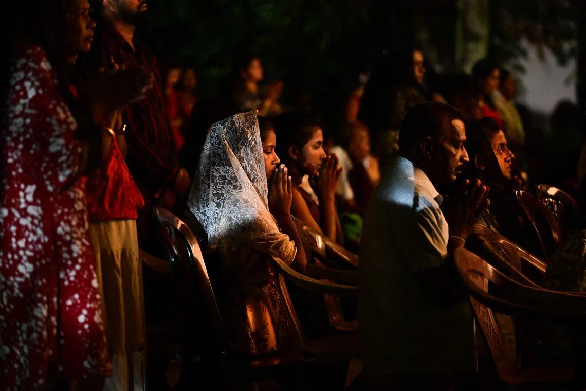 Christians devotees pray during a Christmas mass at the Saint Francis Xavier's Church in Halpe, on Dec 25.