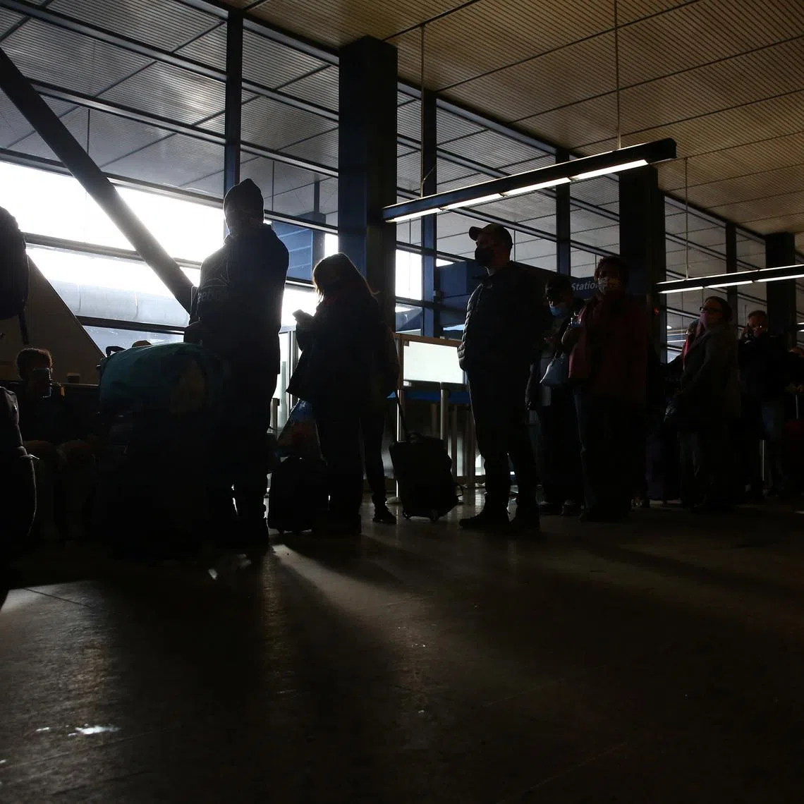 FILE PHOTO: People wait in a long assistance line at Seattle-Tacoma International Airport (Sea-Tac) in Seattle, Washington, U.S. December 27, 2021. REUTERS/Lindsey Wasson/File Photo