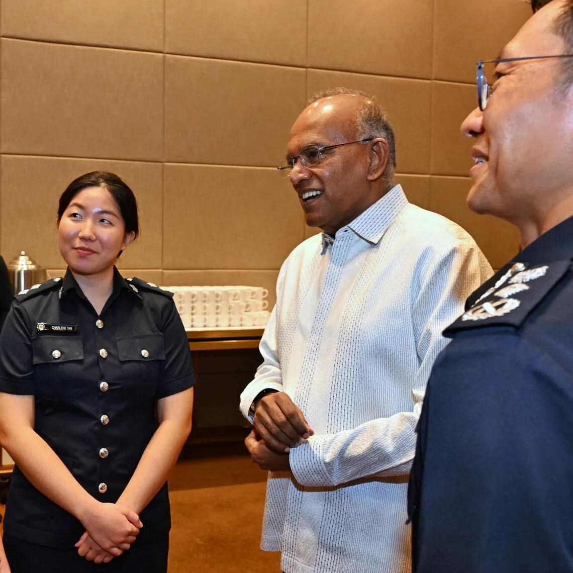 Senior Minister and Coordinating Minister for National Security K. Shanmugam (2nd from right) and Commissioner of Police How Kwang Hwee (right) speaking to SPF scholarship recipients Charlene Tan and Raynen Ngoh on Aug 18.