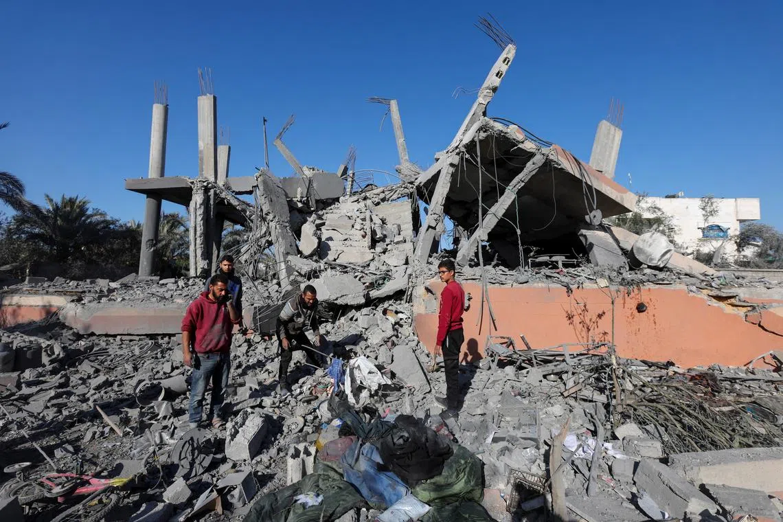 Palestinians search for belongings at the site of an Israeli strike on a house, amid the Israel-Hamas conflict, in Deir Al-Balah in the central Gaza Strip December 4, 2024. REUTERS/Ramadan Abed