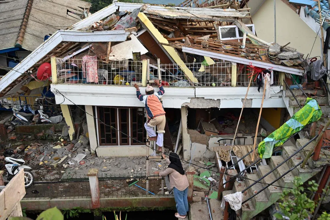 People salvage items from their damaged house following a 5.6-magnitude earthquake that killed at least 162 people, with hundreds injured and others missing in Cianjur on Nov 22, 2022. 