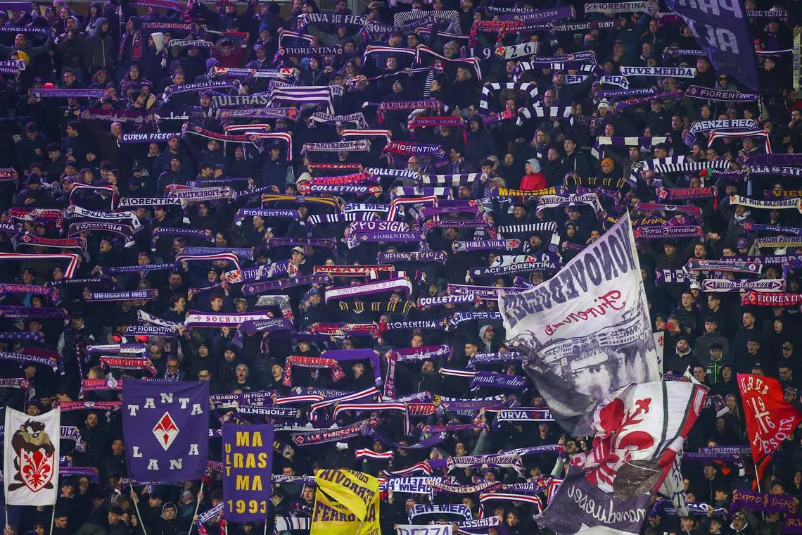 Fiorentina supporters hold up scarves in the stands during a Serie A match, in Florence, Italy, March 22, 2026. REUTERS/Guglielmo Mangiapane