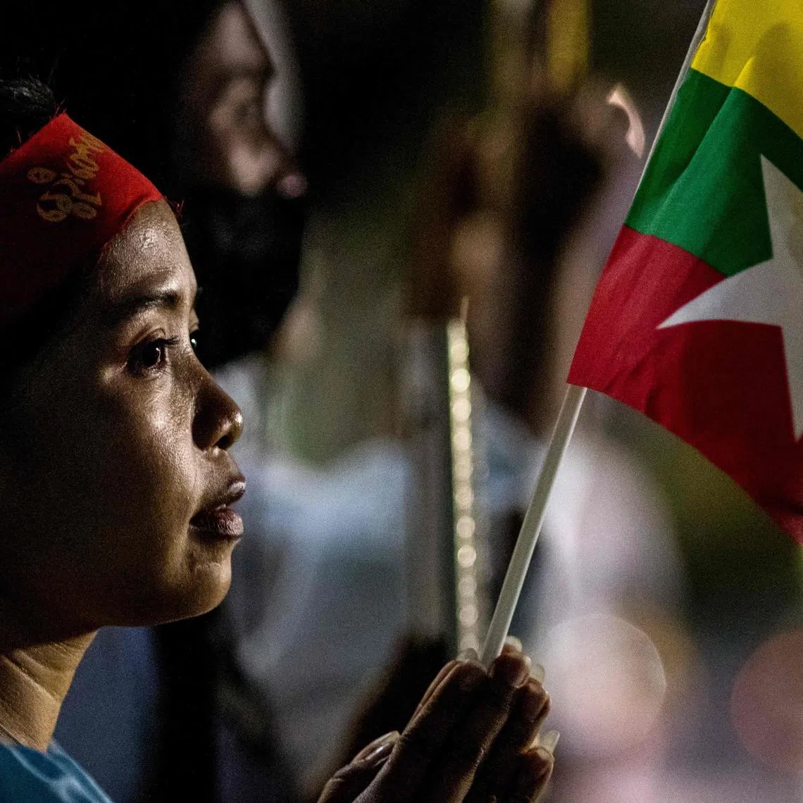 A woman attends a rally by Myanmar migrants living in Thailand outside the United Nations ESCAP building in Bangkok on March 5, 2021.