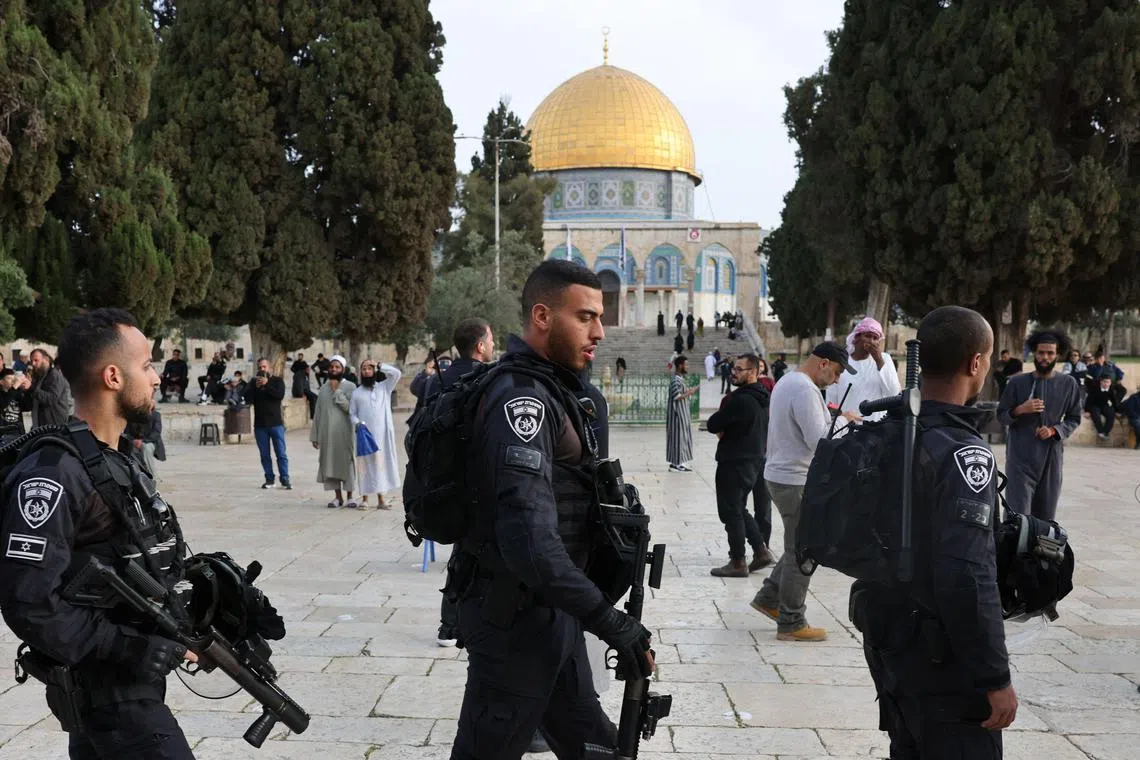 Jewish visitors walk protected by Israeli security forces at the Al-Aqsa mosque compound, also known as the Temple Mount complex to Jews, in Jerusalem on April 9.