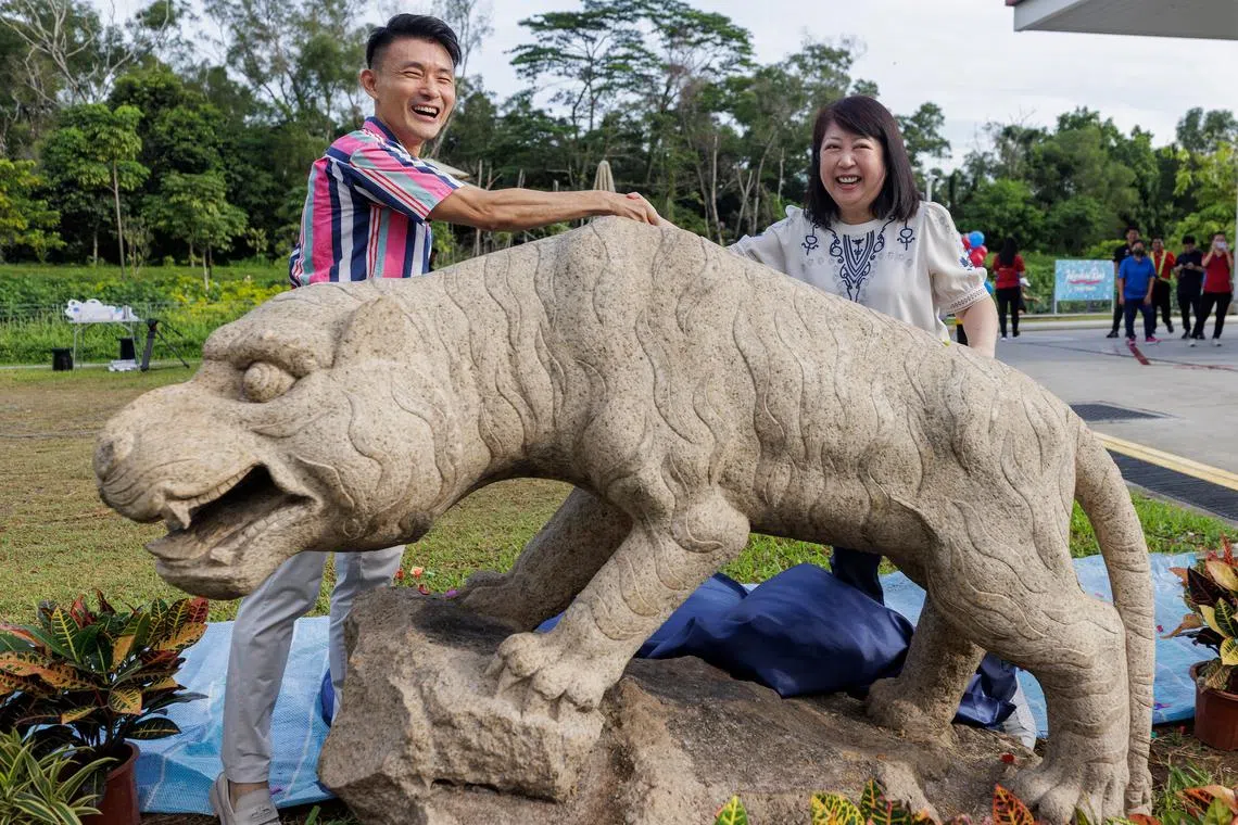 Mr Baey Yam Keng (left) and Ms Thia Ling LIng unveiling the tiger statue at the Esso station at Tampines Avenue 9 on Nov 25..