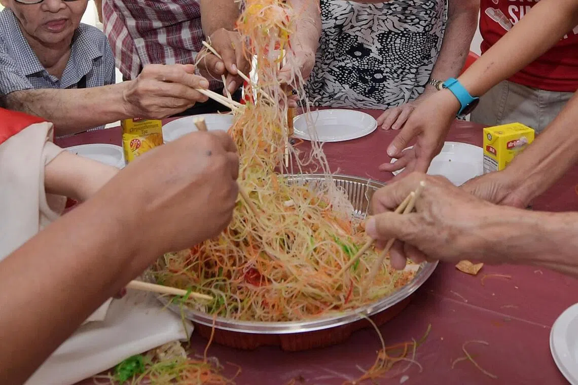 People tossing yusheng during Chinese New Year for luck and prosperity.