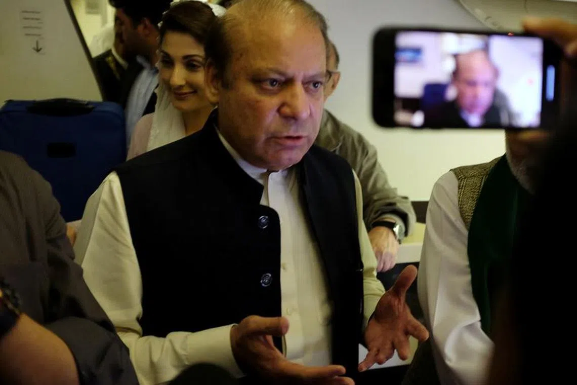 FILE PHOTO: Ousted Pakistani Prime Minister Nawaz Sharif gestures as he boards a Lahore-bound flight due for departure, at Abu Dhabi International Airport, UAE July 13, 2018. REUTERS/Drazen Gorgic/File Photo