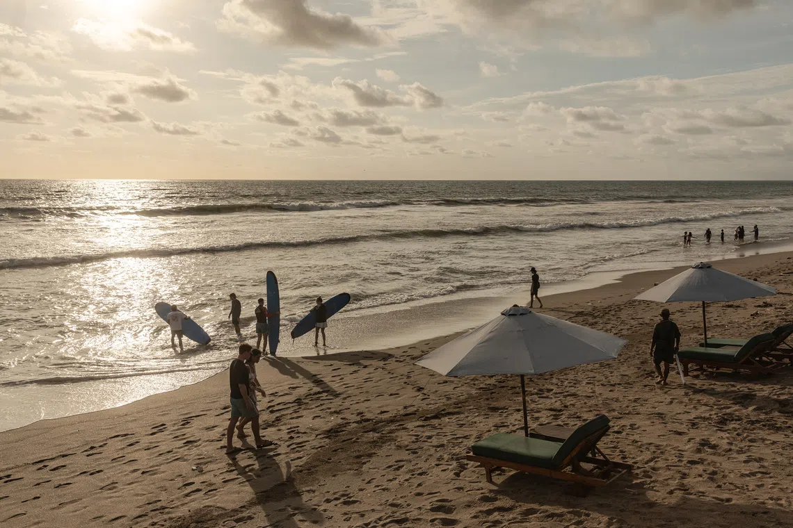 Surfers at Batu Belig beach in Bali on Nov 28. The development of mass tourism on the island was a deliberate strategy to resuscitate an economy shattered by the mass killings, historians say.