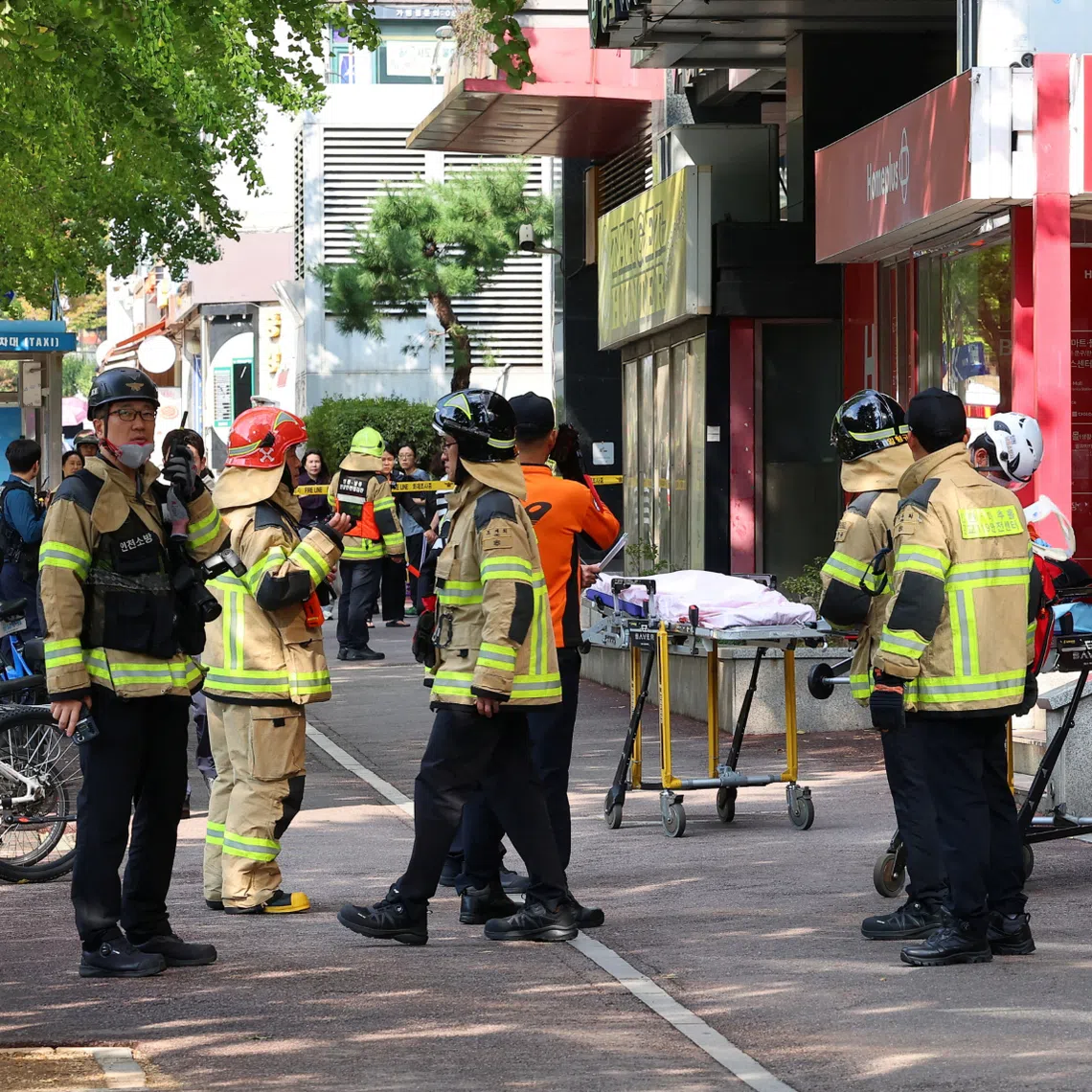 Firefighters and policemen gather outside the scene where the stabbing incident occurred in Incheon, South Korea, on Oct 13.