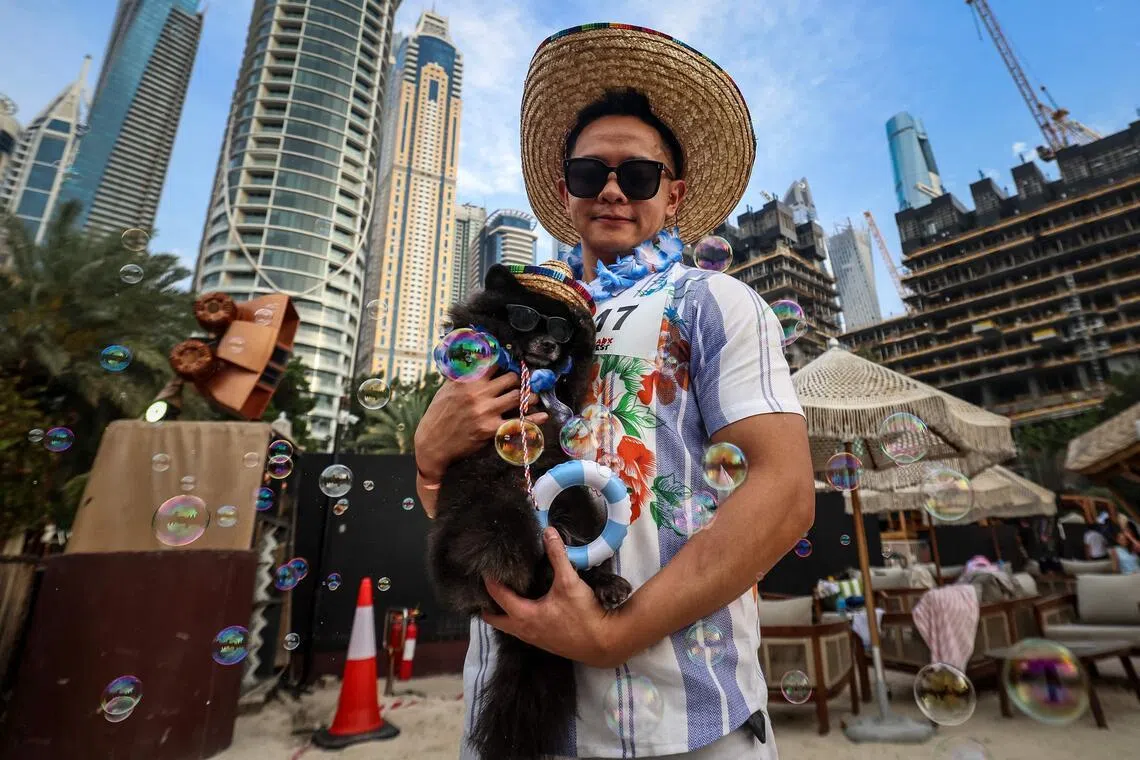 A man poses for a picture with his dog during the Barkfest dog festival at Barasti Beach in Dubai on April 4. 