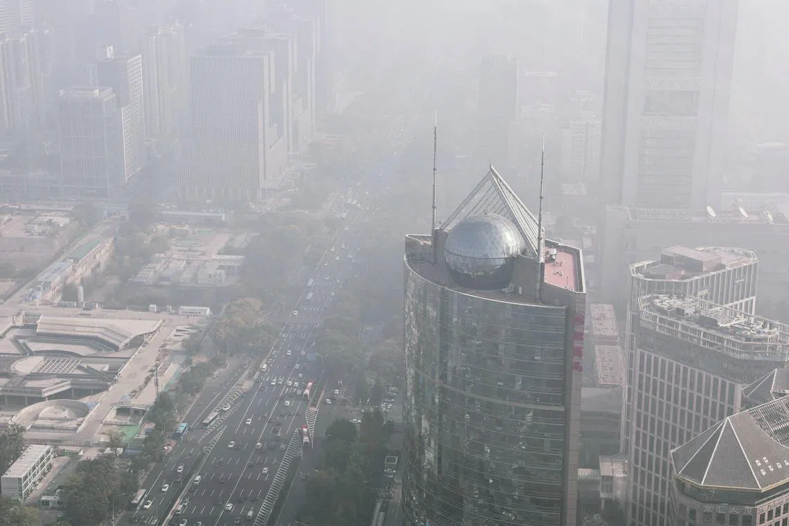 Cars move on a street in Beijing's Central Business District as the city is shrouded in smog, on Nov 1, 2023. 