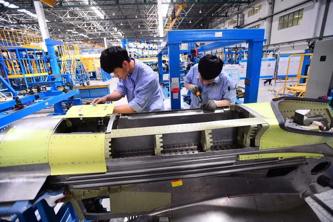 FILE PHOTO: Workers assemble part of the engine assembly for China's self developed C919 passenger aircraft at a factory of Shenyang Aircraft Corporation in Shenyang, Liaoning province, China March 14, 2018. Picture taken March 14, 2018.  REUTERS/Stringer/File Photo