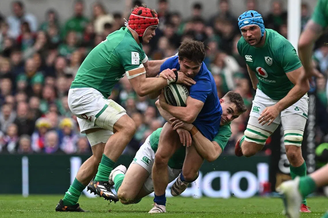 France's scrum-half Antoine Dupont (centre) is tackled during the Six Nations match between Ireland and France in Dublin.
