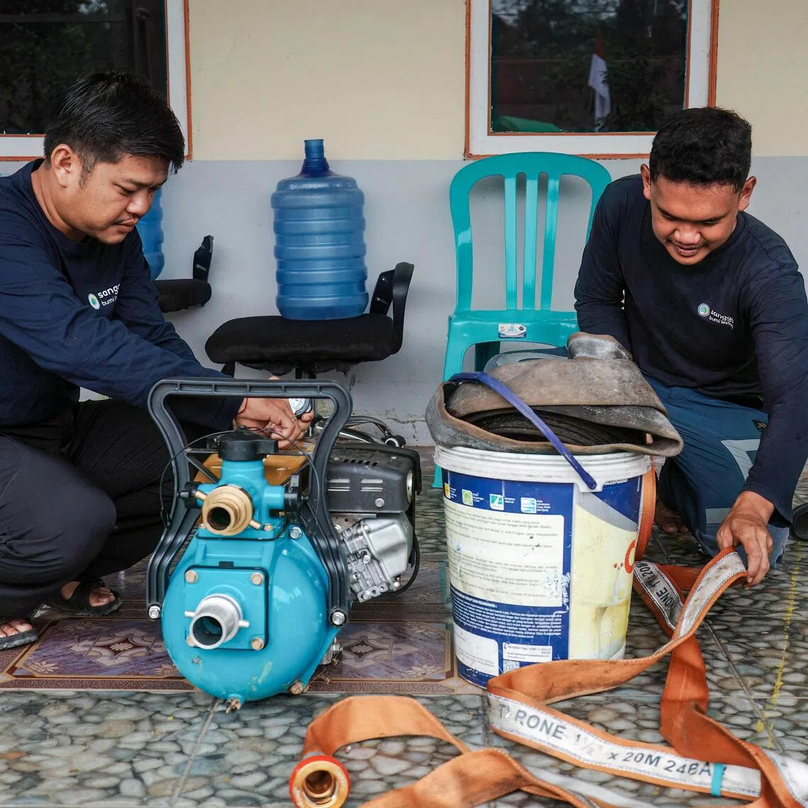 Sangga Bumi Lestari agricultural coordinator Kristoforus Sinyong (right) and restoration and regenerative agriculture staff member Hidayat prepare equipment to battle wildfires in Kapuas Hulu, West Kalimantan.