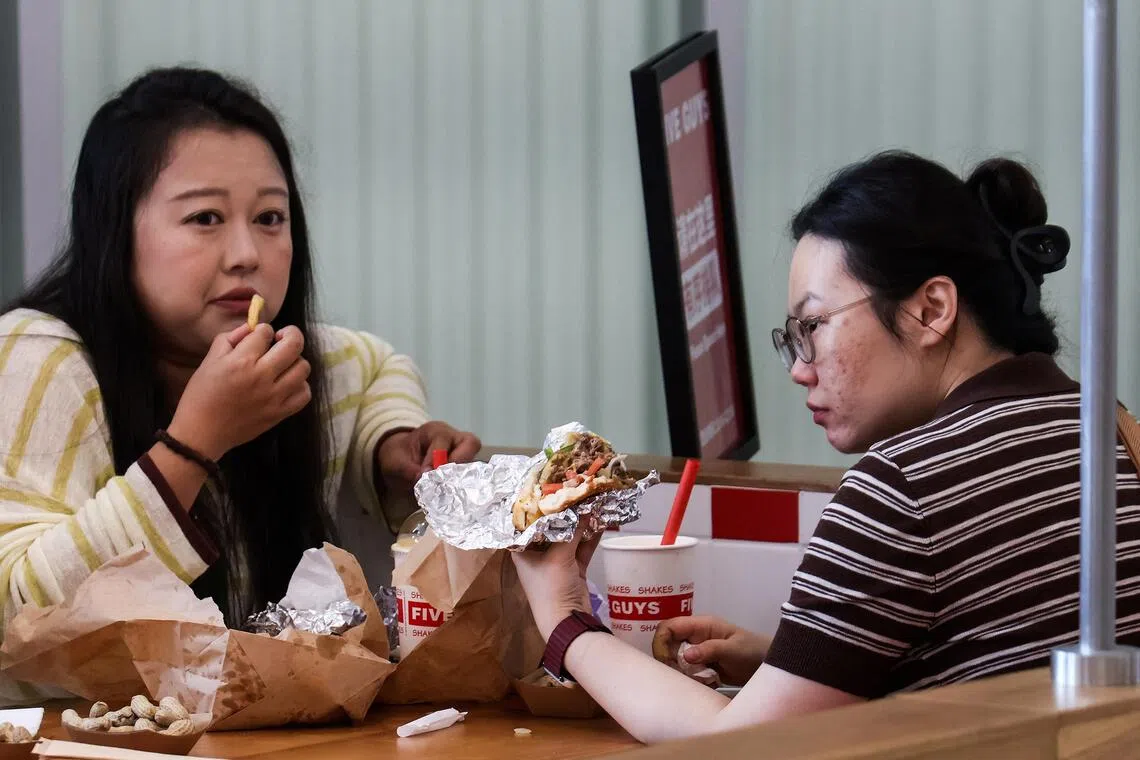 Diners at a Five Guys fast-food restaurant after the US burger chain opened its first two locations in Beijing earlier in August.