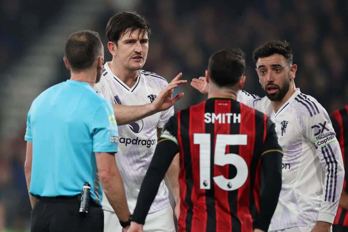 Manchester United's Harry Maguire reacts with Bruno Fernandes after he is shown a red card by referee Stuart Attwell.