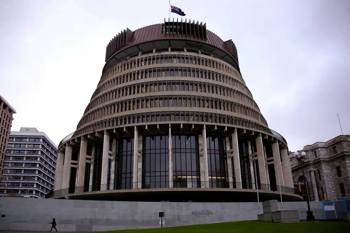 FILE PHOTO: A pedestrian walks past the New Zealand parliament building known as the Beehive in central Wellington, New Zealand, July 3, 2017.  REUTERS/David Gray/File Photo