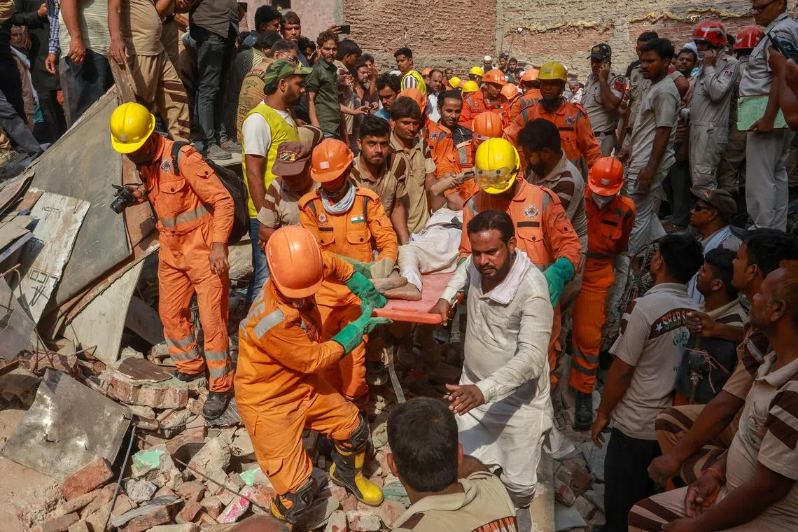 Rescuers carrying a person on a stretcher after extracting them from the rubble of a collapsed residential building in New Delhi, on April 19.