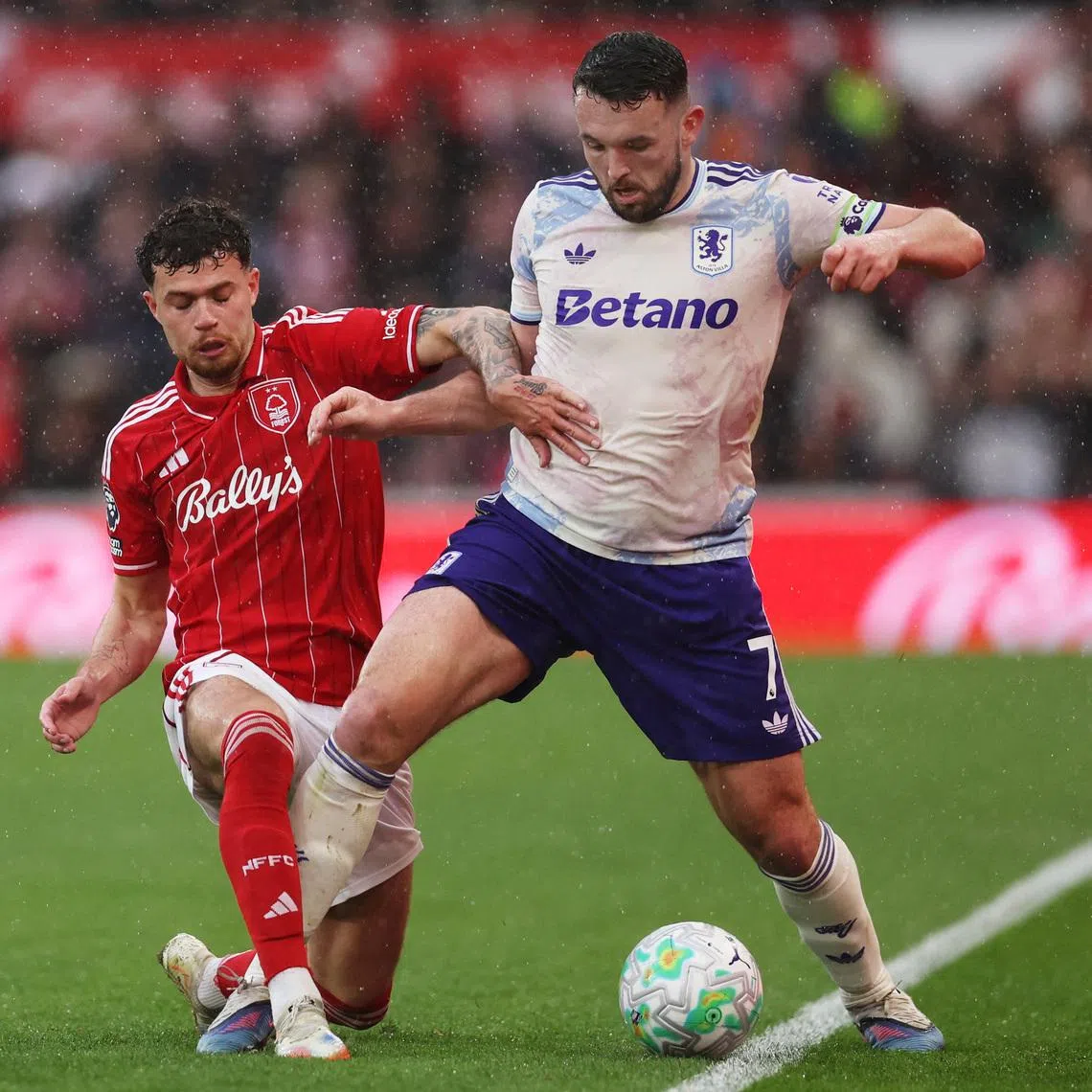 Soccer Football - Premier League - Nottingham Forest v Aston Villa - The City Ground, Nottingham, Britain - April 12, 2026 Aston Villa's John McGinn in action with Nottingham Forest's Neco Williams REUTERS/Chris Radburn