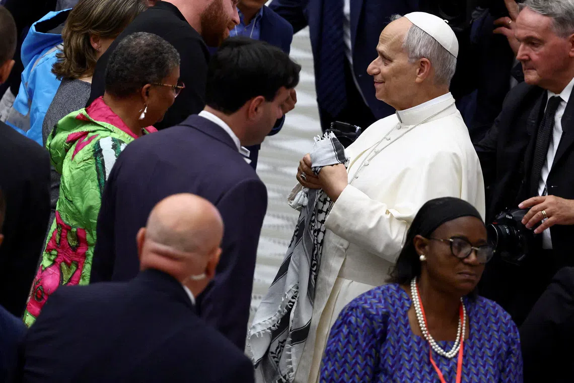 Pope Leo XIV holds a Palestinian keffiyeh on a day of the meeting with participants in the World Meeting of Popular Movements in the Paul VI hall, at the Vatican, October 23, 2025. REUTERS/Yara Nardi      TPX IMAGES OF THE DAY