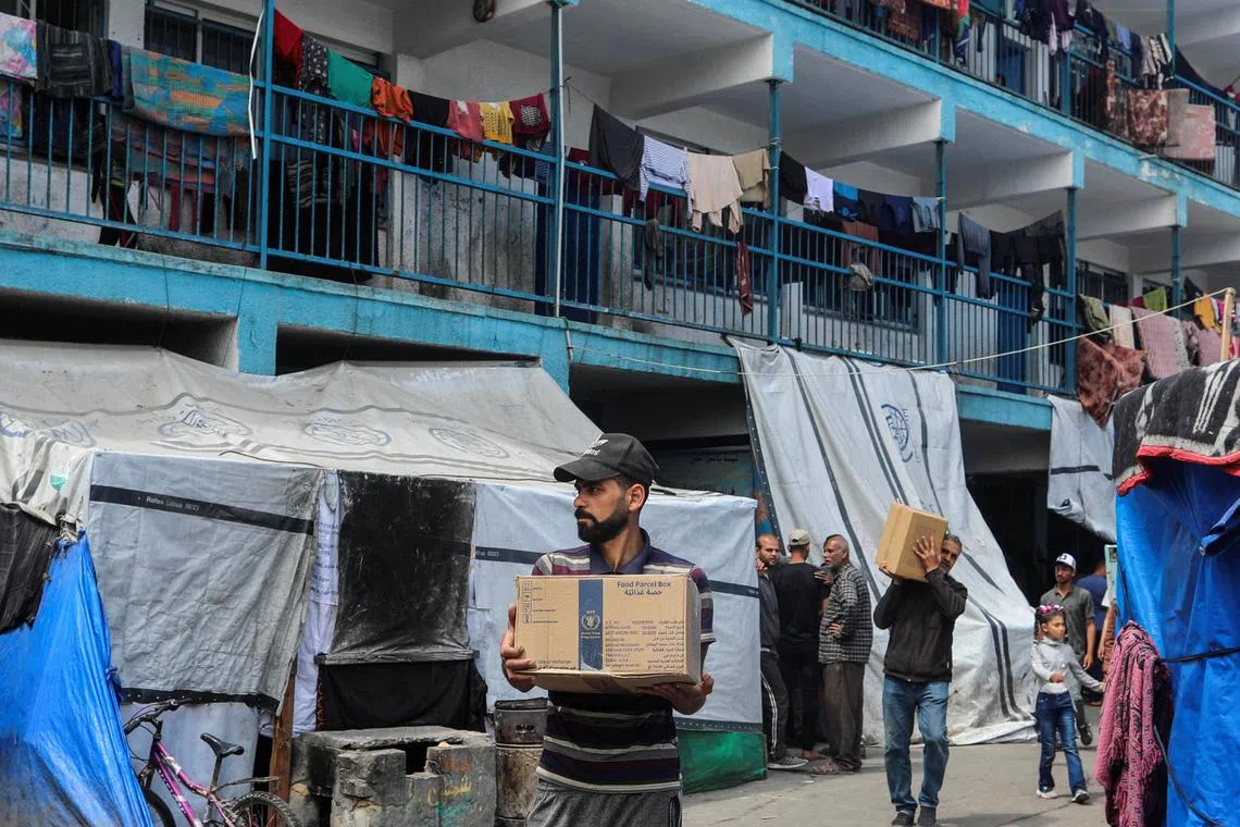 Palestinians carry boxes of aid before the Eid al-Fitr holiday, marking the end of the Muslim holy fasting month of Ramadan, in the central Gaza Strip, on April 8.