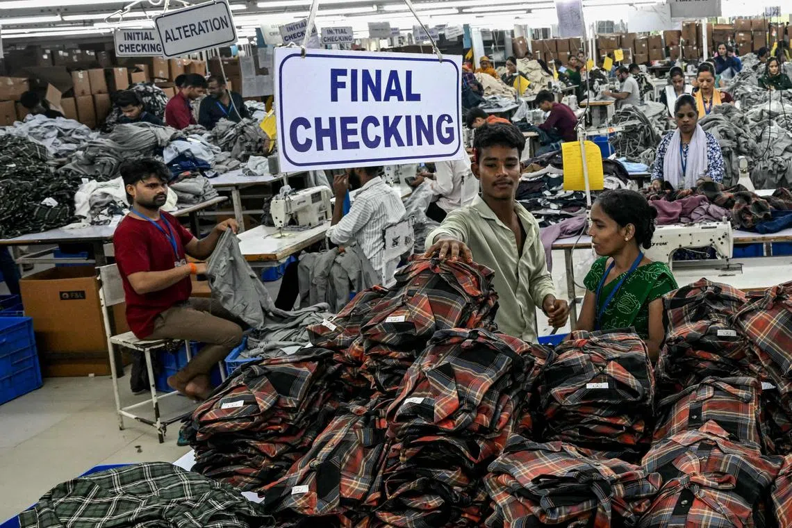 Employees work at the apparel manufacturing unit at Bhiwandi in the Thane district of India's Maharashtra state on July 30, 2025. Indian exporters were bracing for higher US tariffs to kick in on July 30 as prospects dimmed for an interim trade deal between New Delhi and Washington before the August 1 deadline. (Photo by Indranil MUKHERJEE / AFP)