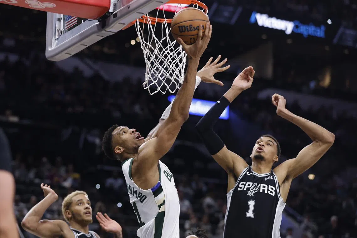 The Milwaukee Bucks' Giannis Antetokounmpo dunking past San Antonio Spurs' Victor Wembanyama.
