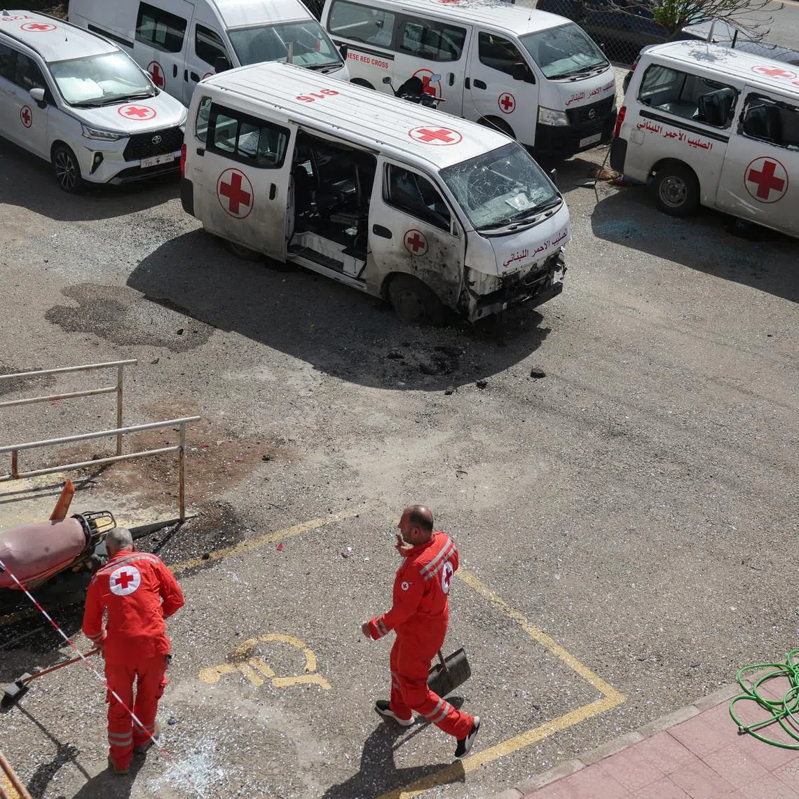 Staff members clean shattered glass after a drone strike damaged vehicles and a building, slightly injuring three workers, in Tyre, Lebanon, April 13, 2026. REUTERS/Louisa Gouliamaki