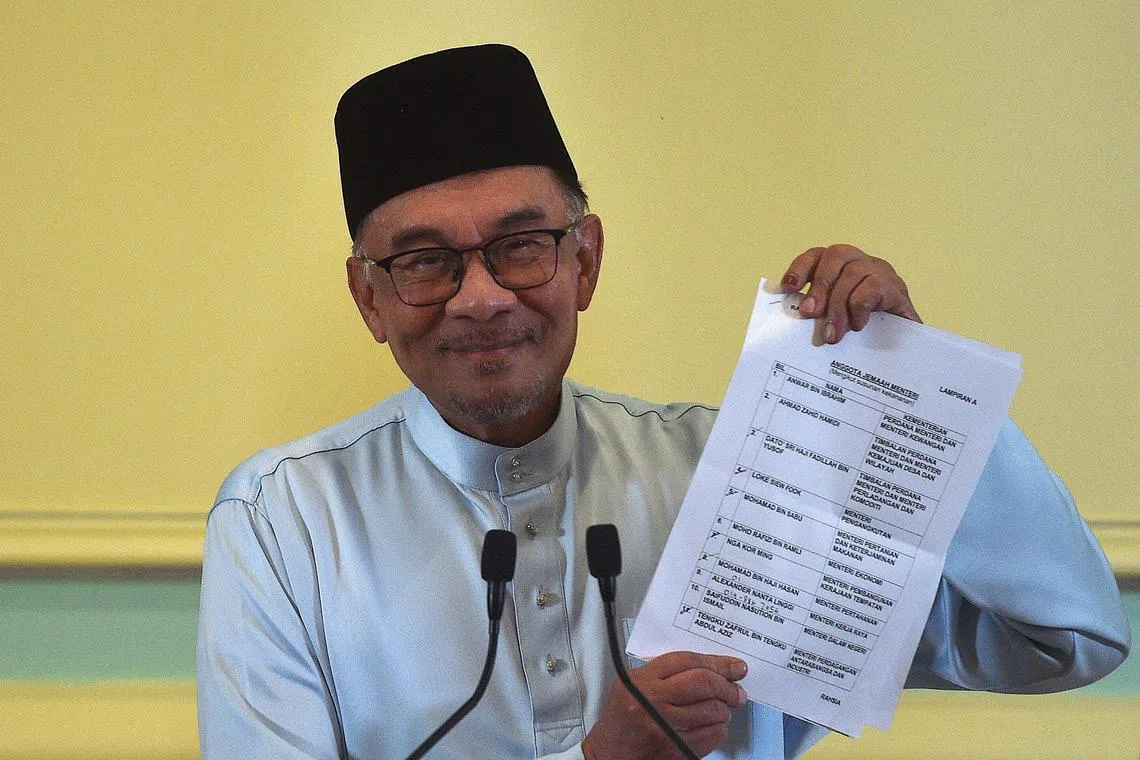 Malaysia’s Prime Minister Anwar Ibrahim holds a document during a press conference to announce new cabinet members at the Prime Minister’s office in Putrajaya on December 2, 2022. (Photo by Arif Kartono / AFP)