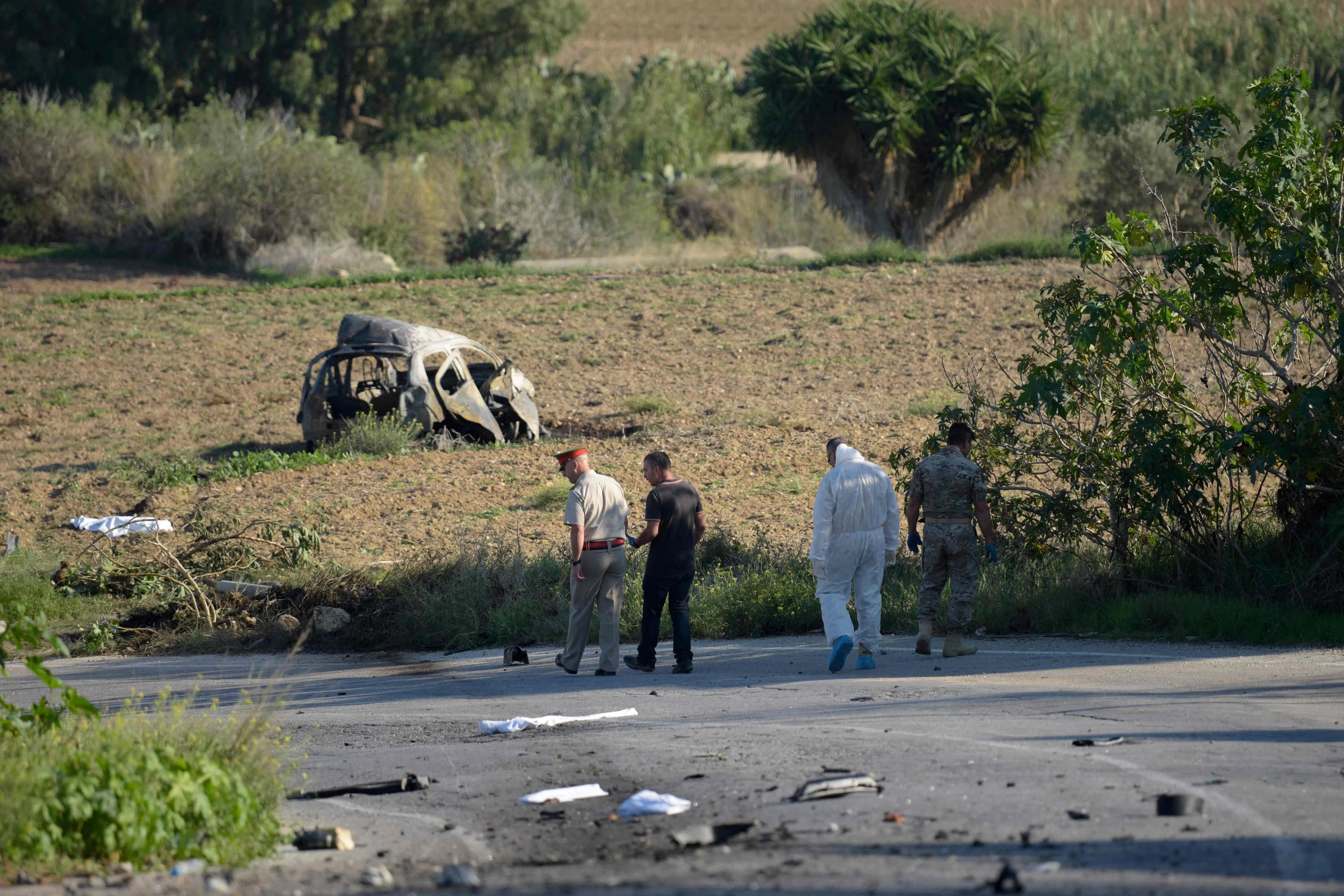 (FILES) Police and forensic experts inspect the wreckage of a car bomb believed to have killed journalist and blogger Daphne Caruana Galizia close to her home in Bidnija, Malta, on October 16, 2017. The force of the blast broke her car into several pieces and catapulted the journalist's body into a nearby field, witnesses said. She leaves a husband and three sons. The man accused of ordering the 2017 murder of a hard-hitting investigative journalist in Malta finally faced a court on July 1, 2026, marking a key moment in the criminal case that rocked the tiny nation. Businessman Yorgen Fenech is charged with orchestrating the assasination of Daphne Caruana Galizia, 53, a prominent public figure and vocal critic who was killed by a bomb placed in her car near her home. (Photo by AFP) / Malta OUT