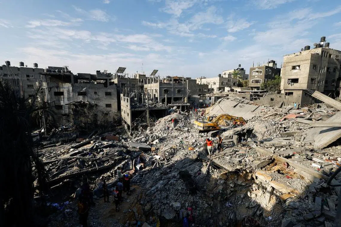 Emergency personnel work at the site of Israeli strikes on houses, as the conflict between Israel and Palestinian Islamist group Hamas continues, in Khan Younis in the southern Gaza Strip, October 27, 2023. REUTERS/Mohammed Salem