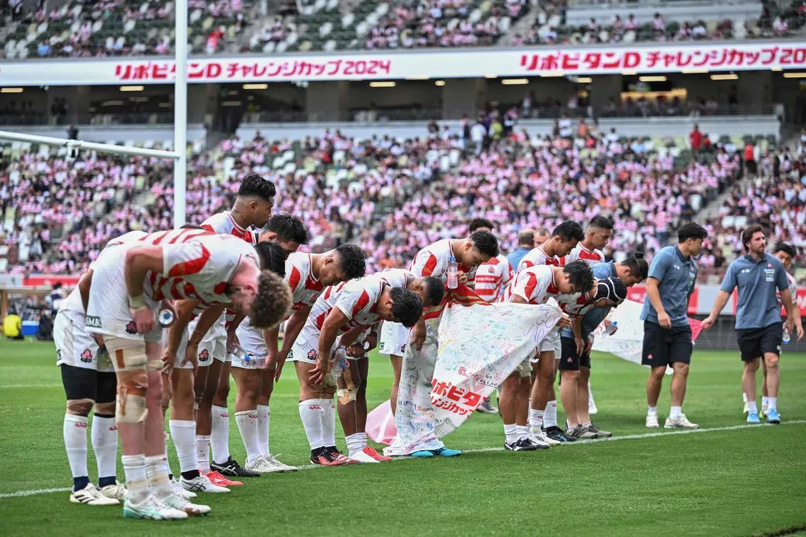 Japan players bow toward their fans after their loss in the international rugby union match between Japan and England at the National Stadium in Tokyo on June 22, 2024. (Photo by Philip FONG / AFP)