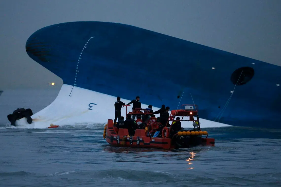 Maritime police search for missing passengers in front of the South Korean ferry Sewol which sank at the sea off Jindo, on April 16, 2014.